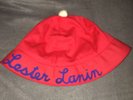 Red Cotton Lester Lanin Hat With A White Ball On Top & His Name In Blue Script