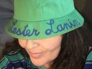 Green Cotton Lester Lanin Hat With A White Ball On Top & His Name In Blue Script